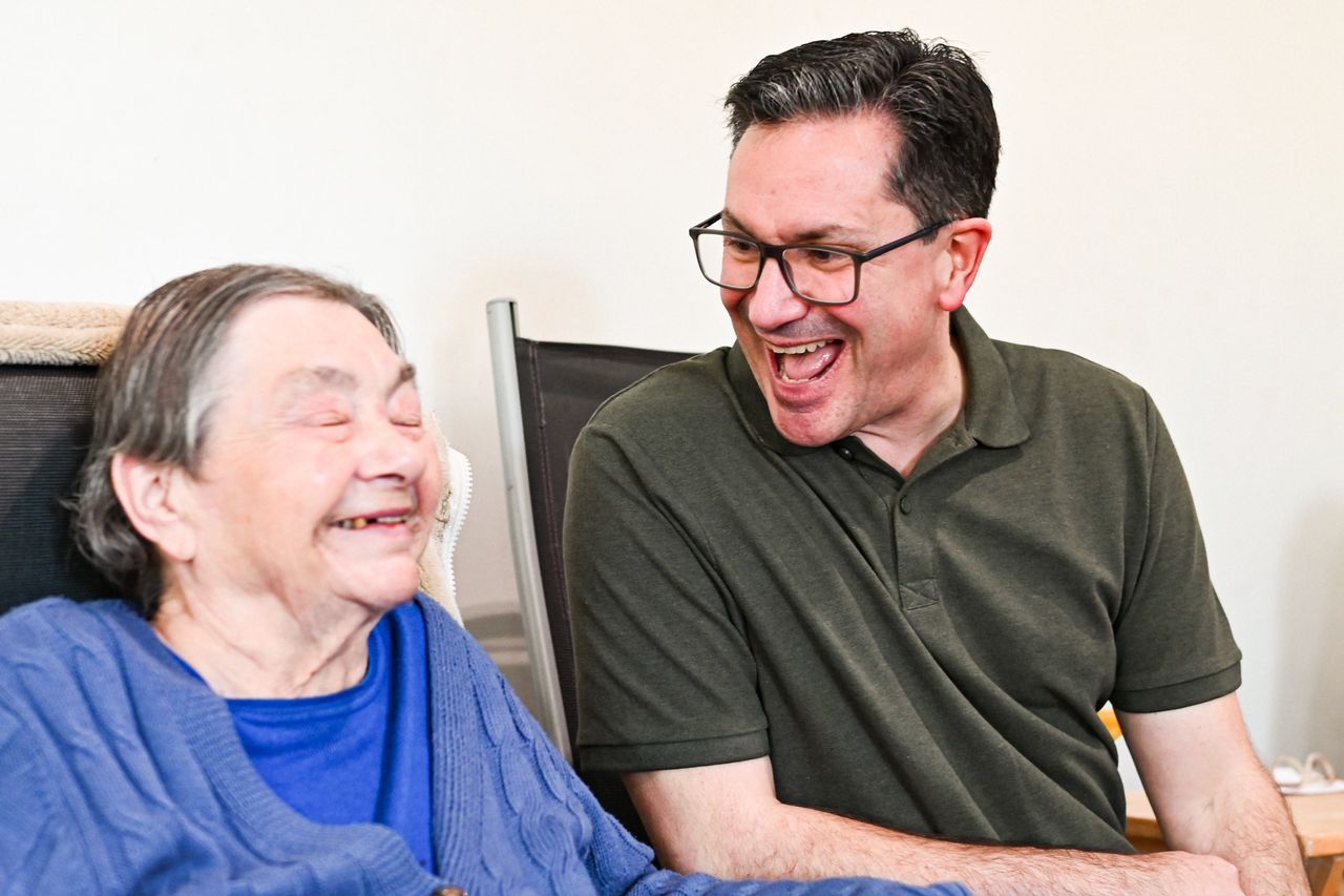 services-01 A man and an elderly woman share laughter indoors. Captured in Norwich, UK.